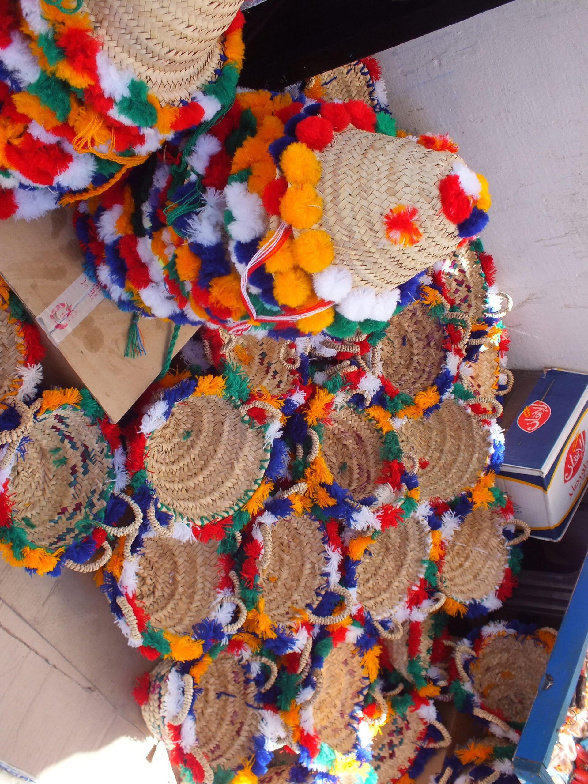 Colorful handmade woven hats and baskets displayed in Chefchaouen